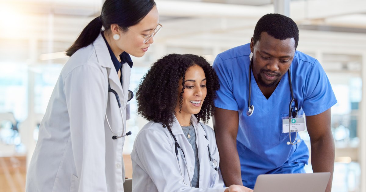 Reading Product Specs When Buying Medical Supplies Online Two medical professionals look over the shoulder a sitting medical professional who's pointing at a laptop screen.