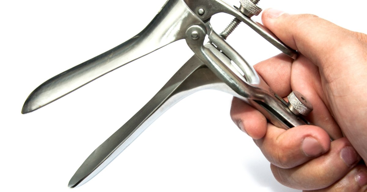 Cleaning and Sterilization Tips for Reusable Vaginal Specula A close-up view shows a person holding a metal vaginal speculum in their hand. They are opening the speculum.