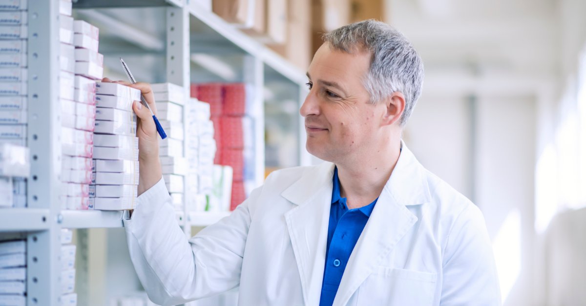Comparing Custom Birth Kits vs. Pre-Assembled Kits A male medical professional is holding a clipboard and a pen while observing medical supplies on a shelving unit.