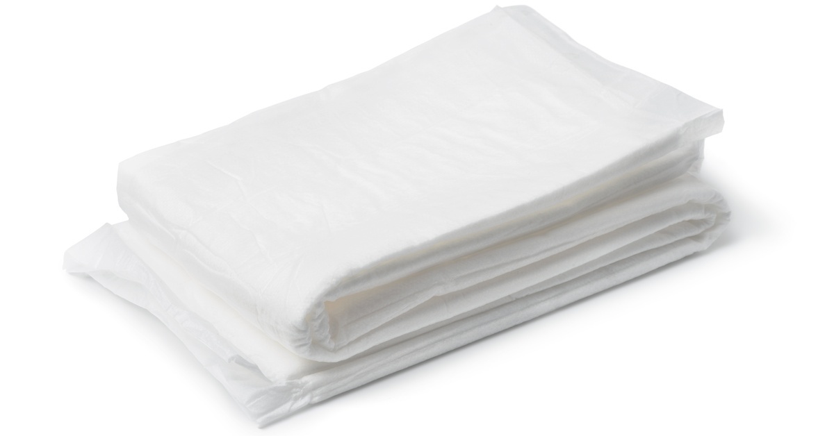A stack of folded white sterile absorbent pads on a white background is essential for post-birth care.