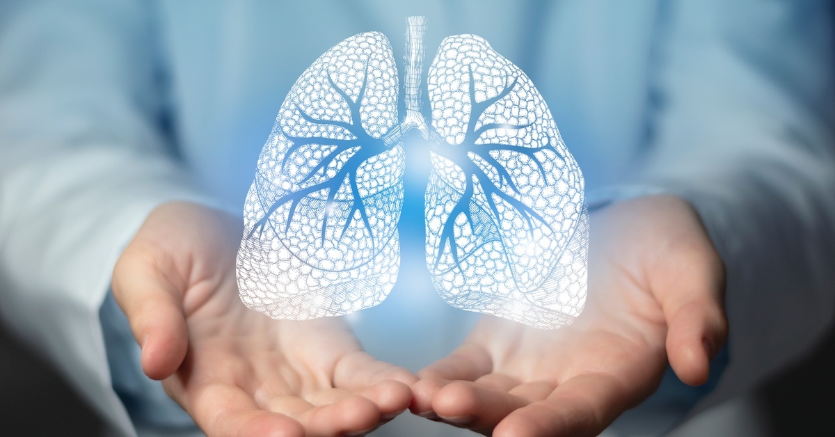 A man wearing a white jacket outstretches his hands. An intricate graphic of the human lungs appears above his hands. A man wearing a white jacket outstretches his hands. An intricate graphic of the human lungs appears above his hands.